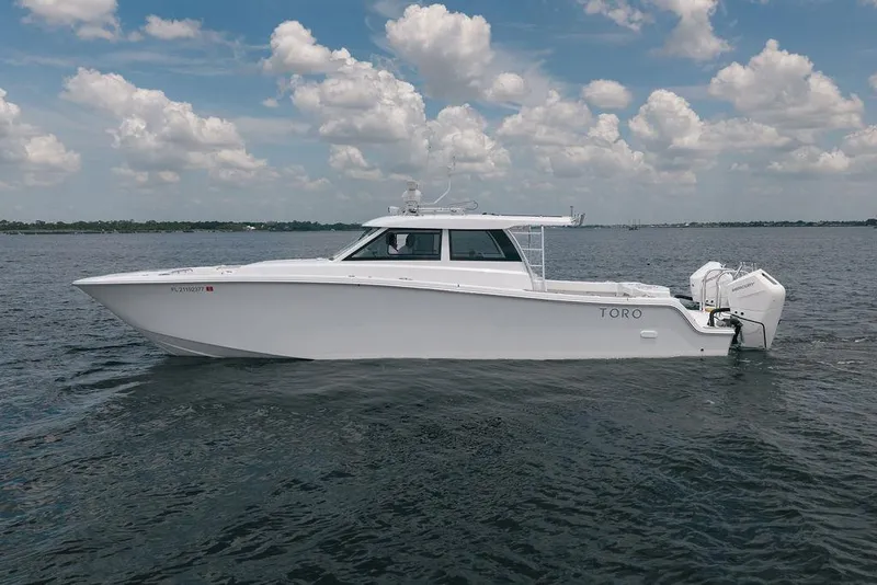 Slide: The Image of 2026 Toro Yachts Toro 42 cruising on a calm sea under a partly cloudy sky. - 9