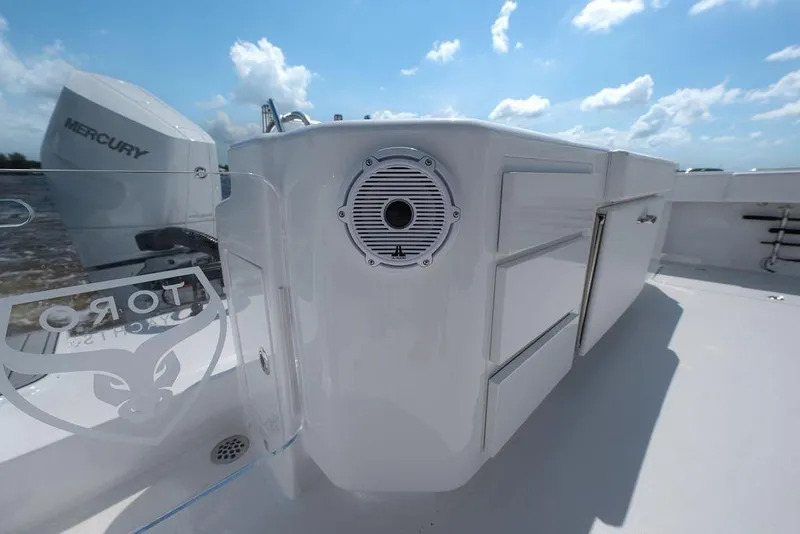 Slide: The Image of 2026 Toro Yachts Toro 42 deck with Mercury engine and sleek design under blue sky. - 17