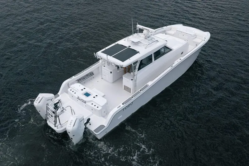 Slide: The Image of 2026 Toro Yachts Toro 42 cruising on open water, showcasing sleek design and powerful engines. - 2