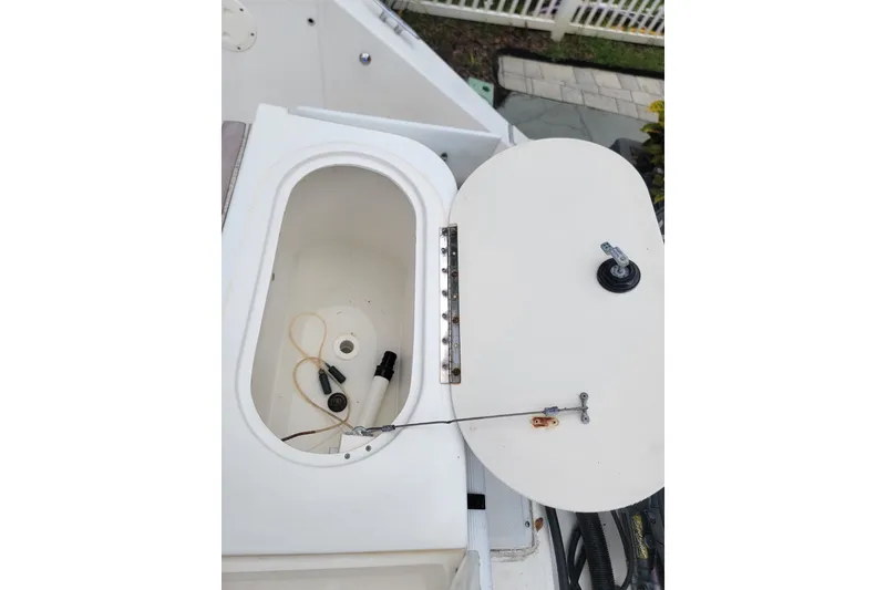 Slide: The Image of 1999 Mako 252 Center Console boat compartment with open hatch and visible wiring. - 26