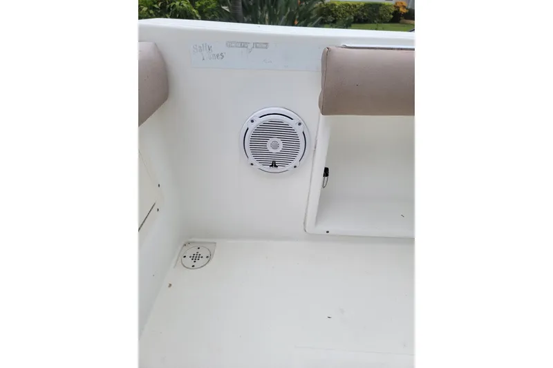 Slide: The Image of Interior of a 1999 Mako 252 Center Console boat, featuring a speaker and seating area. - 33