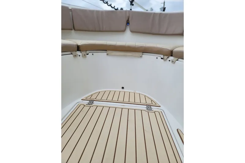 Slide: The Image of 1999 Mako 252 Center Console boat interior with cushioned seating and teak flooring. - 22
