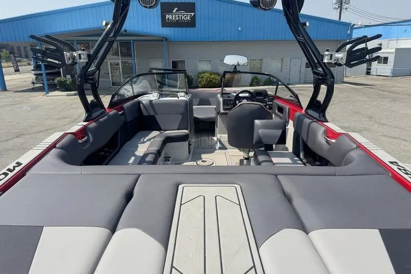 Slide: The Image of 2020 Moomba Max boat interior with seating and dashboard, parked at Prestige dealership. - 13