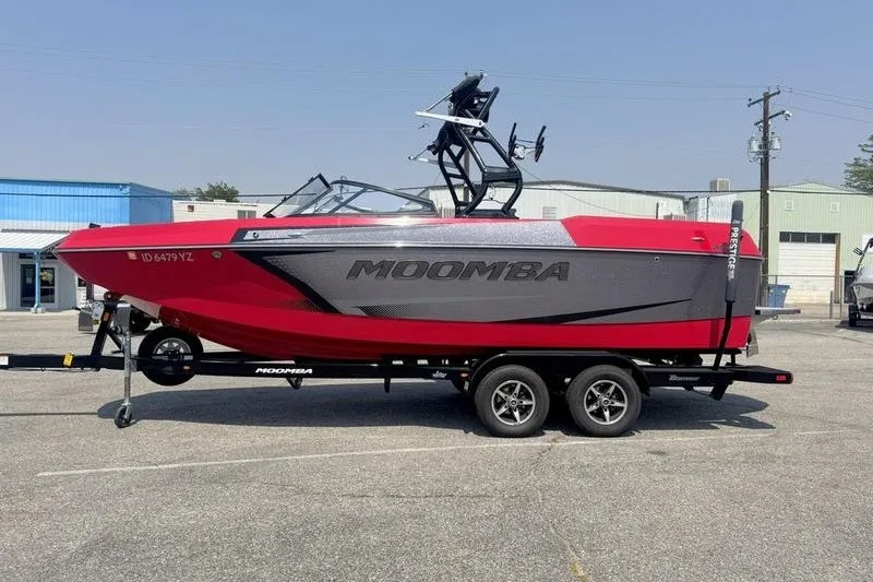 The Image of 2020 Moomba Max boat in red and gray on a trailer, parked outdoors. - 1