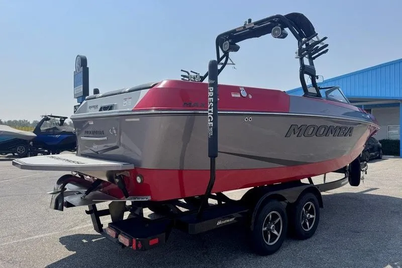 Slide: The Image of 2020 Moomba Max boat on trailer, red and gray, parked outdoors. - 4