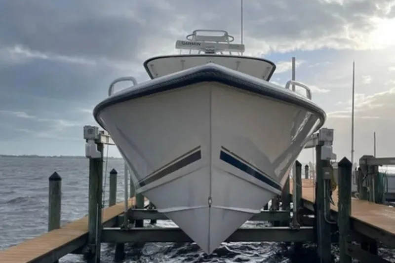 Slide: The Image of 2004 Venture 34 Cuddy boat docked, viewed from the front, under a cloudy sky. - 1