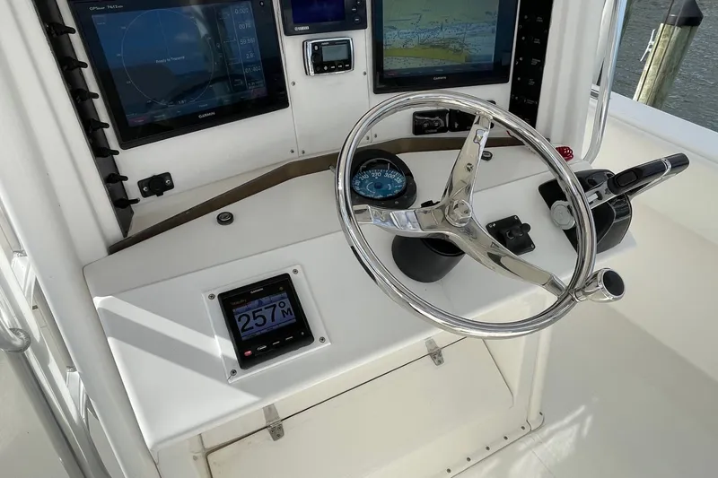 Slide: The Image of 2004 Venture 34 Cuddy helm with steering wheel, navigation screens, and controls. - 14
