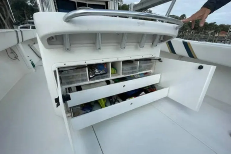 Slide: The Image of 2004 Venture 34 Cuddy boat storage compartments with open drawers and fishing gear. - 10