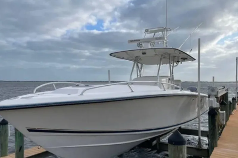 The Image of 2004 Venture 34 Cuddy boat docked by the water under a cloudy sky. - 0