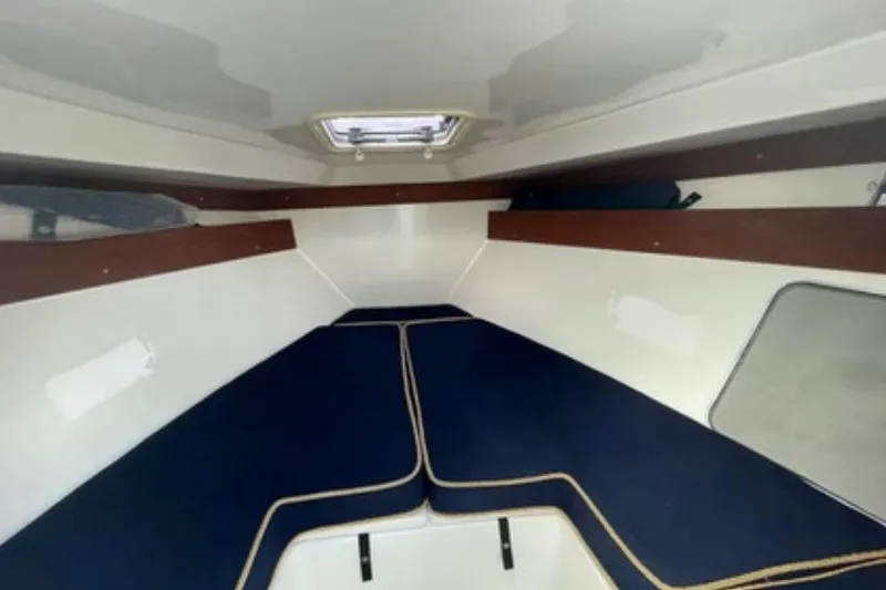 Slide: The Image of 2004 Venture 34 Cuddy cabin interior with blue cushions and wooden accents. - 8