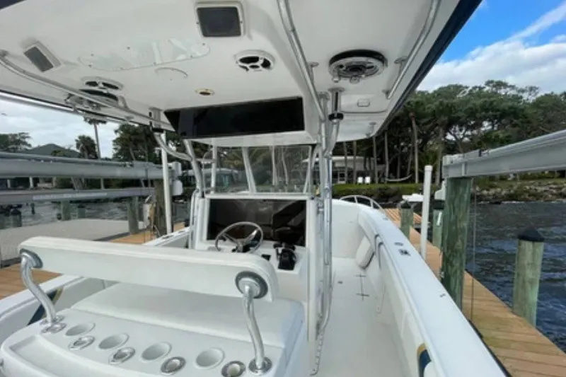 Slide: The Image of 2004 Venture 34 Cuddy boat interior with helm, seating, and rod holders at dock. - 5