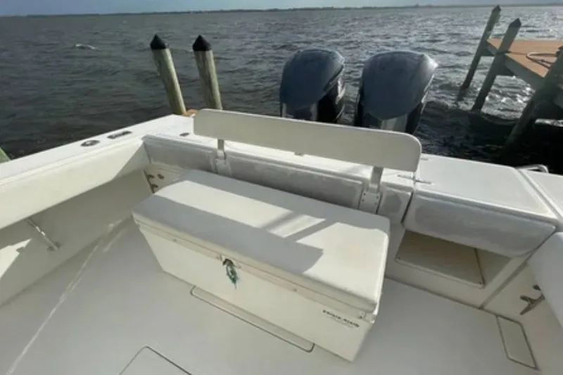 Slide: The Image of 2004 Venture 34 Cuddy boat with dual engines docked by the water. - 9