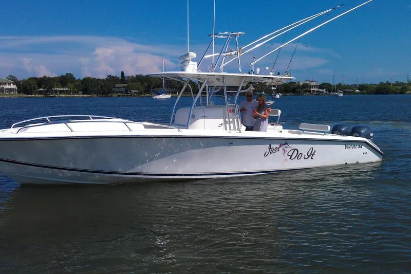 Slide: The Image of 2004 Venture 34 Cuddy boat named "Just Do It" on a calm lake. - 12
