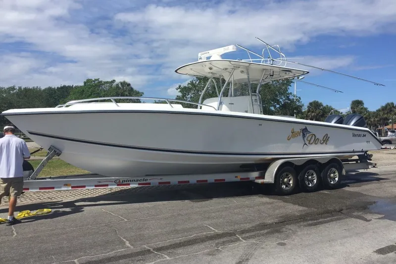 Slide: The Image of 2004 Venture 34 Cuddy boat on trailer, white hull, outdoor setting. - 2