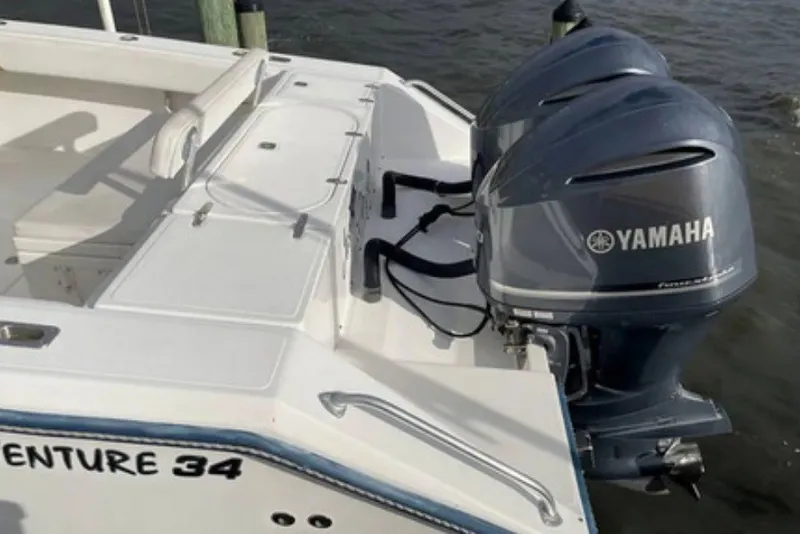 Slide: The Image of 2004 Venture 34 Cuddy boat with dual Yamaha outboard motors docked by the water. - 3