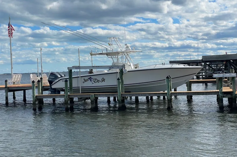 Slide: The Image of 2004 Venture 34 Cuddy boat docked, with "Just Do It" text, under a cloudy sky. - 13