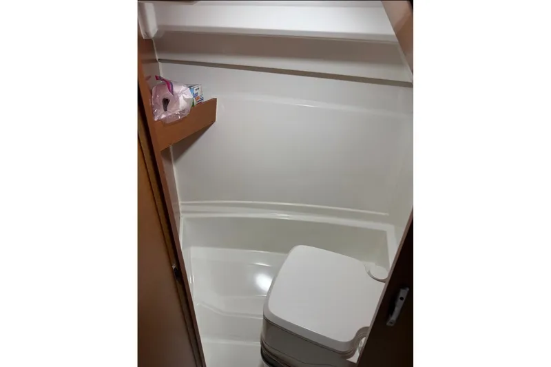 Slide: The Image of Compact bathroom in 2017 Jeanneau Merry Fisher 695 boat, featuring a toilet and storage shelf. - 14