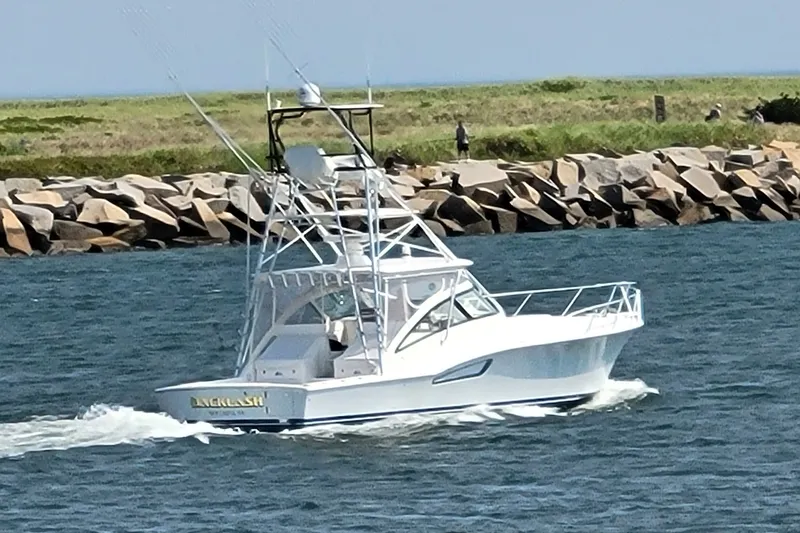 Slide: The Image of 2023 Albemarle 41 Custom Carolina Edition cruising near rocky shoreline. - 22