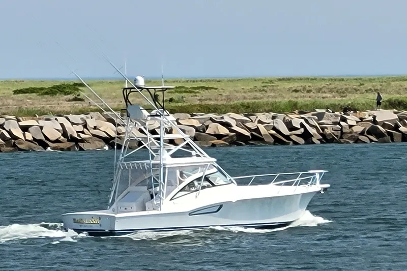 Slide: The Image of 2023 Albemarle 41 Custom Carolina Edition cruising near rocky shoreline. - 3