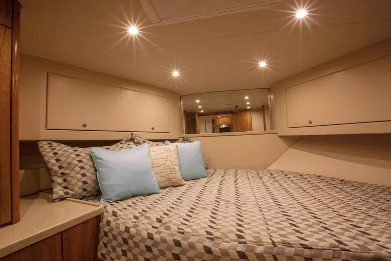 Slide: The Image of The cabin of the 2023 Albemarle 41 Custom Carolina Edition features a large bed and elegant lighting. - 17