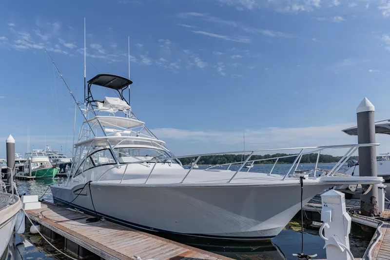 Slide: The Image of 2023 Albemarle 41 Custom Carolina Edition yacht docked at marina under clear blue sky. - 30