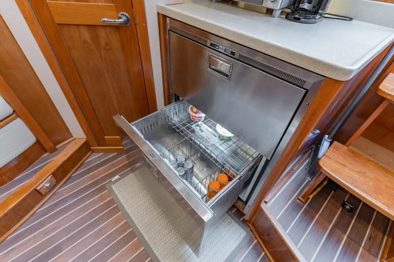 Slide: The Image of 2023 Albemarle 41 Custom Carolina Edition yacht interior with open stainless steel drawer fridge. - 22