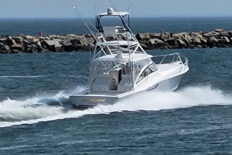 Slide: The Image of 2023 Albemarle 41 Custom Carolina Edition cruising near rocky shoreline. - 2