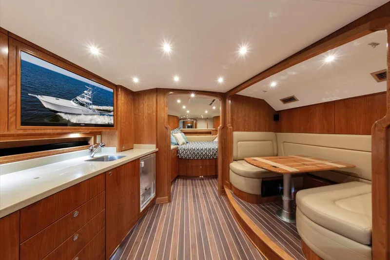 Slide: The Image of Albemarle 41 Custom Carolina Edition 2023: Luxurious interior with wood finish, seating area, and kitchenette. - 16