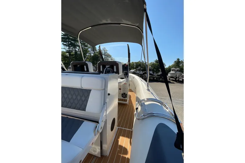 Slide: The Image of 2024 Sealegs 7.5M boat interior with seating and canopy, parked outdoors. - 21