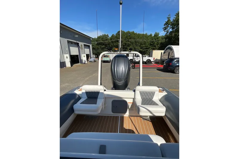 Slide: The Image of 2024 Sealegs 7.5M boat interior with seating and outboard motor in a parking area. - 17