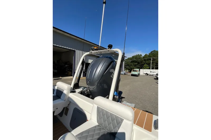 Slide: The Image of 2024 Sealegs 7.5M boat with Yamaha engine, parked outdoors under clear blue sky. - 24