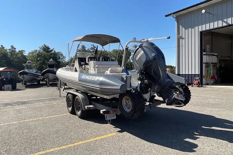 Slide: The Image of 2024 Sealegs 7.5M amphibious boat on trailer, parked near a building. - 8