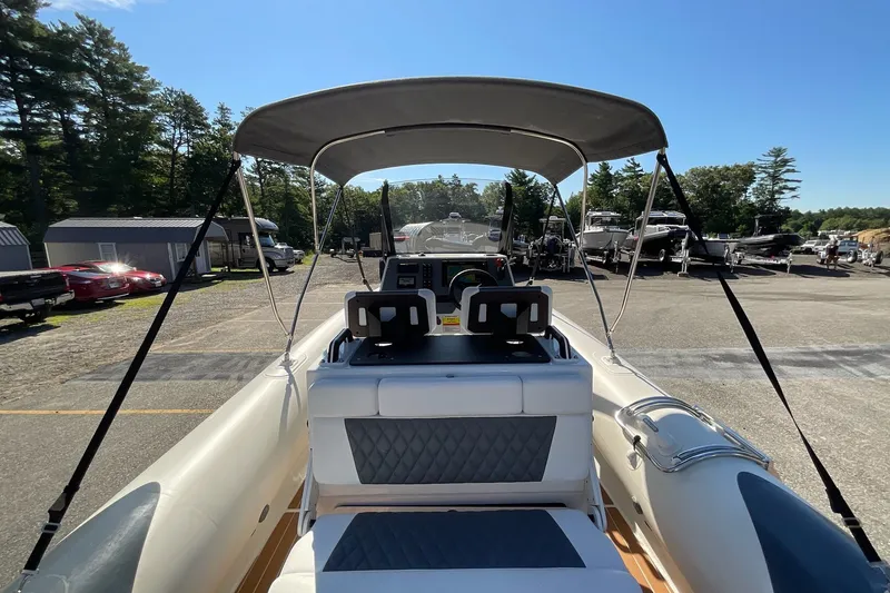Slide: The Image of 2024 Sealegs 7.5M boat with canopy, parked in a marina under clear blue skies. - 23
