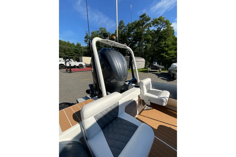 Slide: The Image of 2024 Sealegs 7.5M boat interior with seating and motor, parked outdoors. - 29