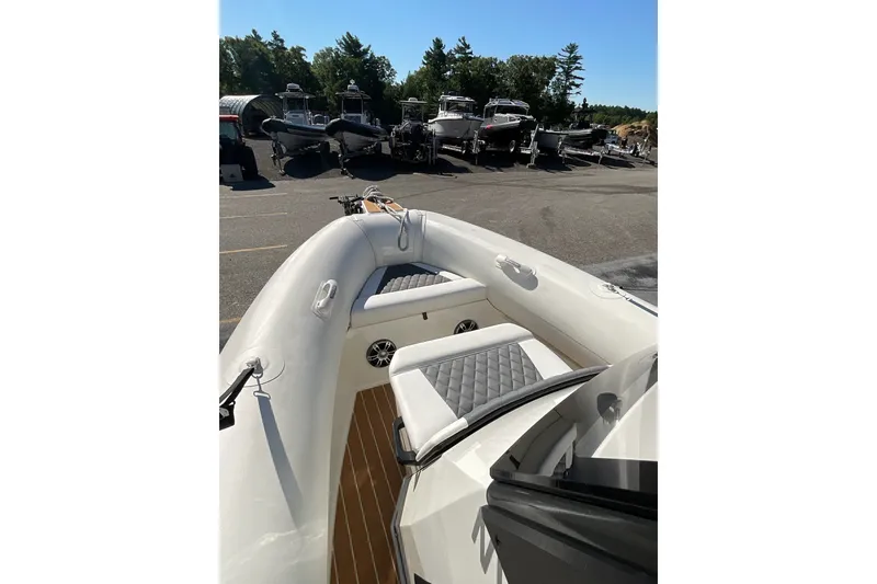 Slide: The Image of 2024 Sealegs 7.5M boat interior with cushioned seating, parked among other boats. - 16