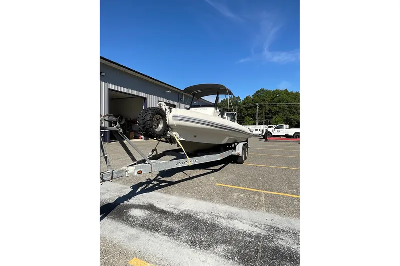 Slide: The Image of 2024 Sealegs 7.5M boat on trailer in parking lot under clear blue sky. - 9