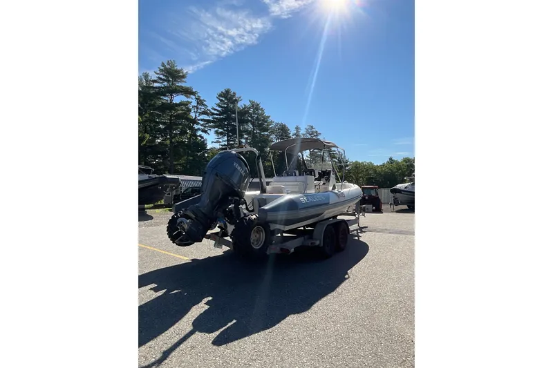 Slide: The Image of 2024 Sealegs 7.5M boat on trailer under sunny sky, surrounded by trees. - 12
