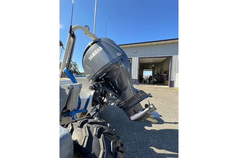 Slide: The Image of 2024 Sealegs 7.5M with Yamaha outboard motor, parked outside a garage. - 33