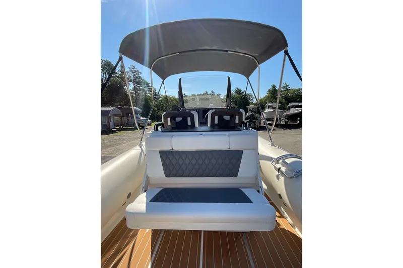 Slide: The Image of 2024 Sealegs 7.5M boat with cushioned seating and canopy under clear blue sky. - 13