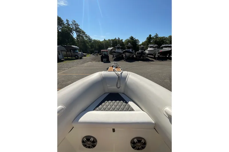 Slide: The Image of 2024 Sealegs 7.5M boat interior with seating, parked outdoors under clear sky. - 32