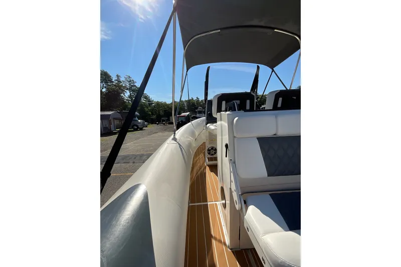 Slide: The Image of 2024 Sealegs 7.5M boat interior with cushioned seating and canopy under sunny sky. - 22