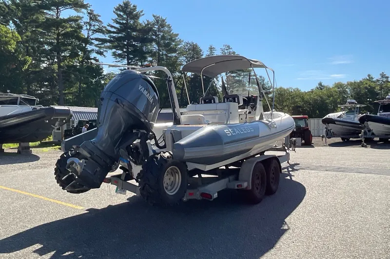 Slide: The Image of 2024 Sealegs 7.5M amphibious boat with Yamaha engine on a trailer in a sunny marina. - 7