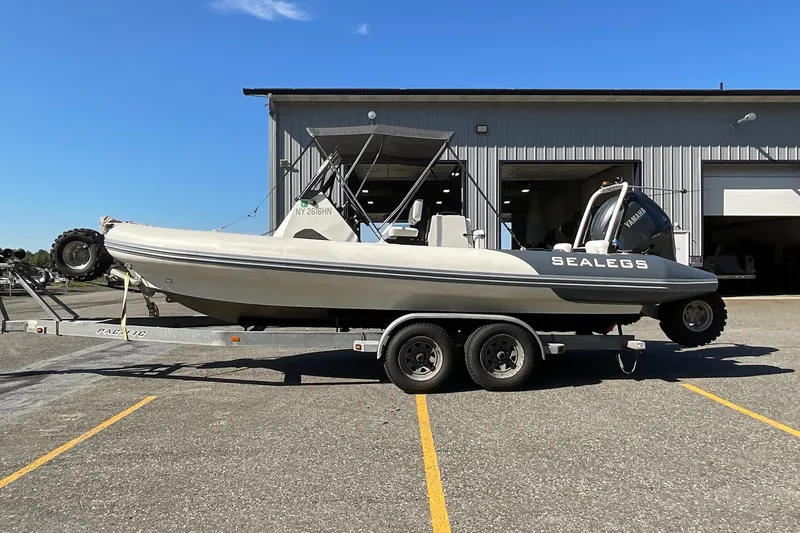 Slide: The Image of 2024 Sealegs 7.5M amphibious boat on trailer, parked outside a warehouse. - 6
