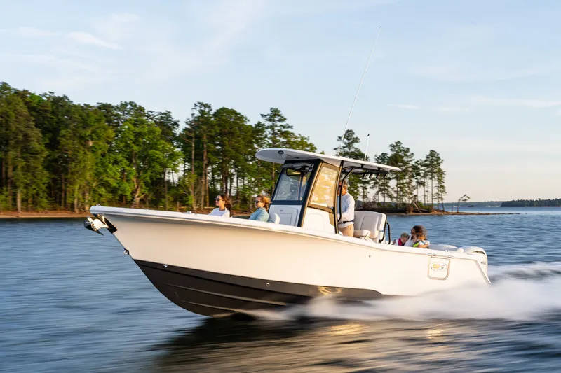 Slide: The Image of 2027 Sea Hunt Ultra 265SE boat cruising on a scenic lake with passengers onboard. - 46