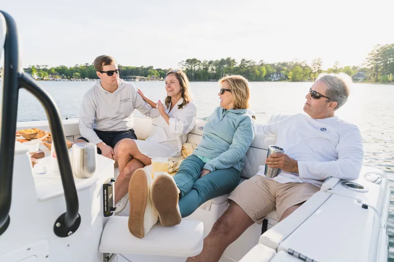 Slide: The Image of People relaxing on a 2027 Sea Hunt Ultra 265SE boat, enjoying a sunny day on the water. - 38