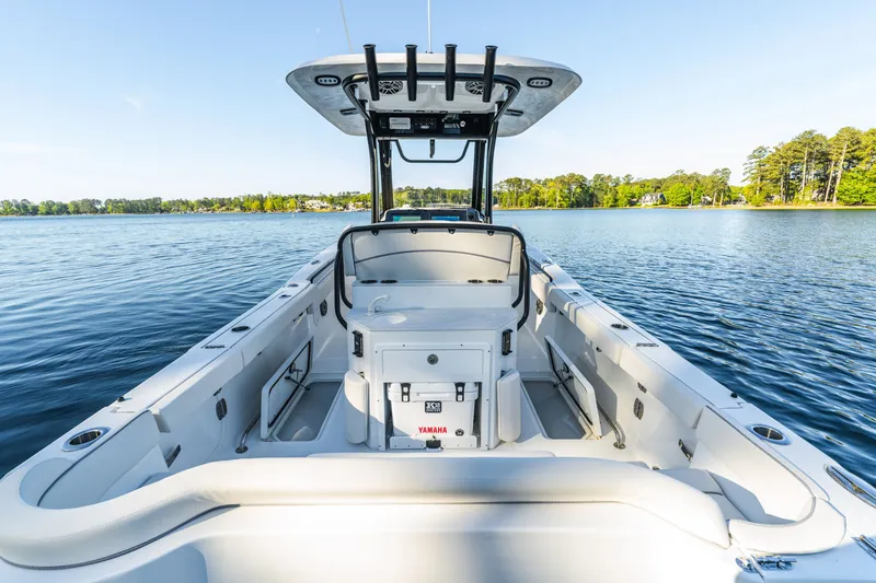 Slide: The Image of 2027 Sea Hunt Ultra 265SE boat on a serene lake, showcasing spacious deck and modern design. - 16