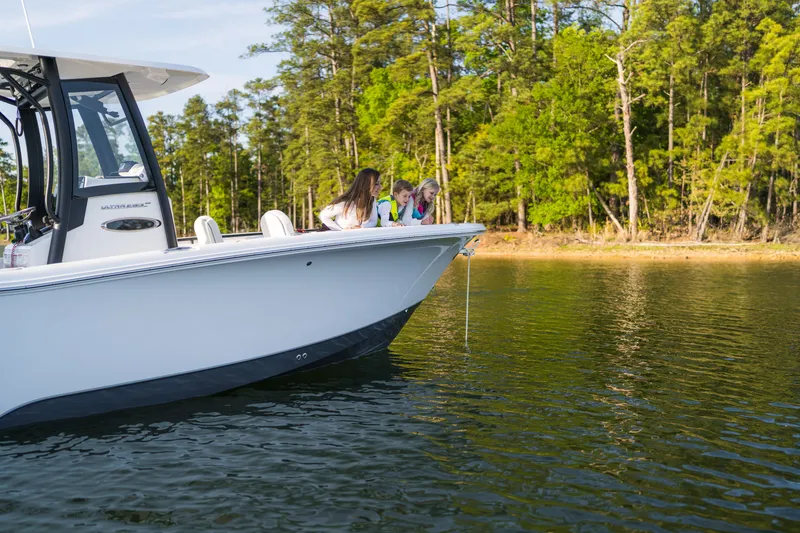 Slide: The Image of 2027 Sea Hunt Ultra 265SE boat with people enjoying a scenic lake view. - 33