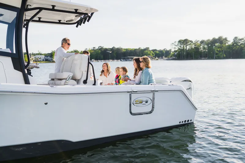 Slide: The Image of Family enjoying a day on a 2027 Sea Hunt Ultra 265SE boat on a serene lake. - 31
