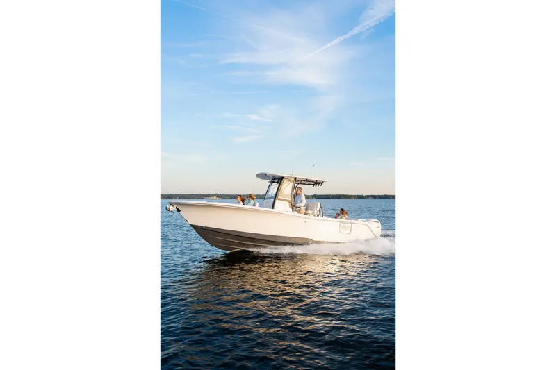 Slide: The Image of 2027 Sea Hunt Ultra 265SE boat cruising on open water under a clear blue sky. - 49