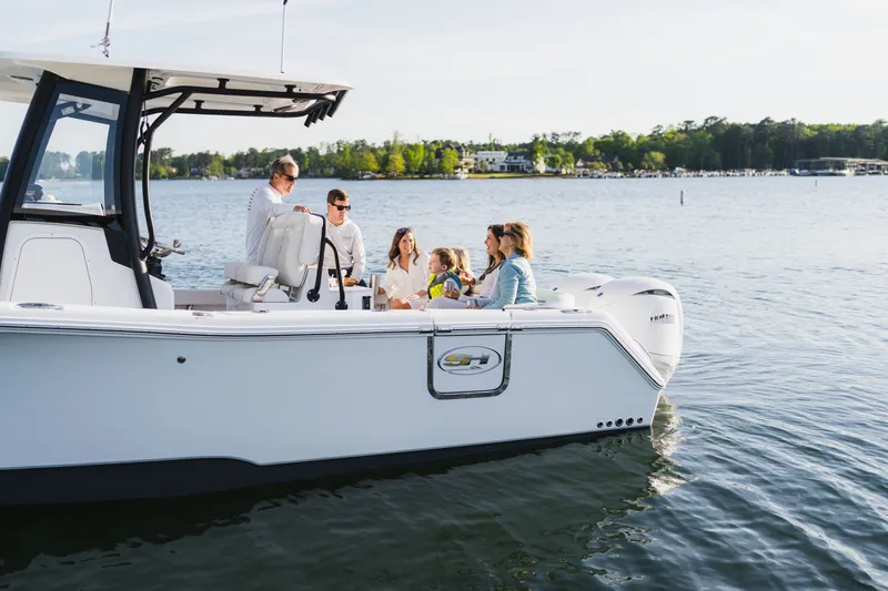 Slide: The Image of People enjoying a day on a 2027 Sea Hunt Ultra 265SE boat on a serene lake. - 32